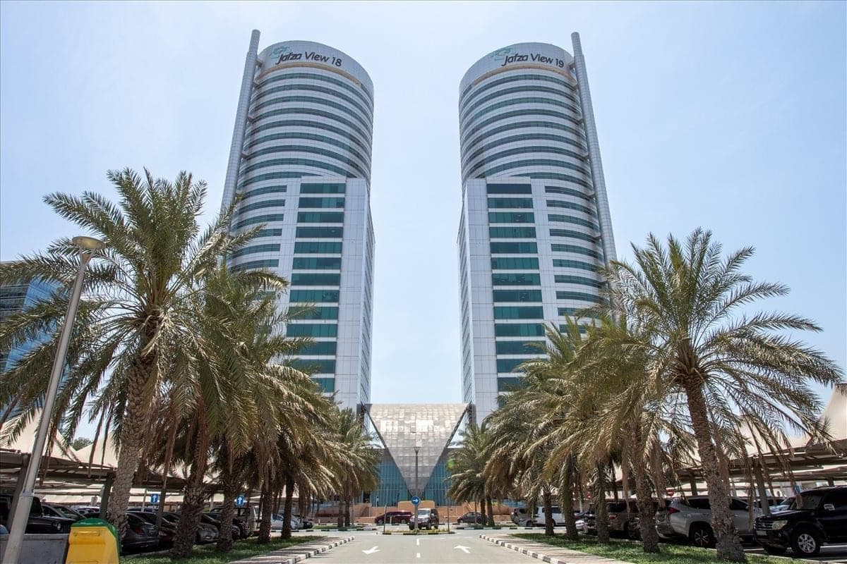 The twin Jafza View towers at Jebel Ali Free Zone, Dubai, flanked by palm trees, with signage reading Jafza View 18 and Jafza View 19