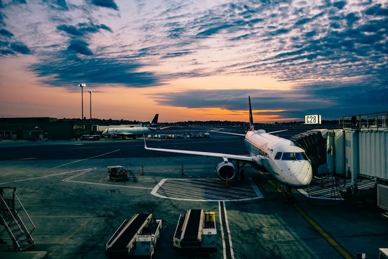 An aircraft parked at an airport gate at dusk
